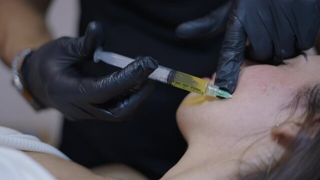 Medical hands injecting prp into a patients face