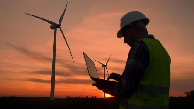 Male Engineer in the Helmet Controls and Maintains the Operation of Wind Turbine