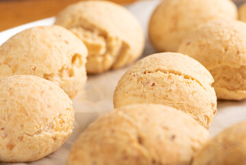 Cheese bread, shape with cheese bread arranged on rustic wood, dark background, selective focus.