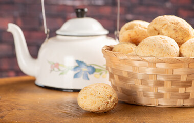 Cheese bread, basket with cheese bread arranged on rustic wood, dark background, selective focus.