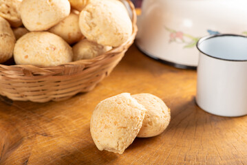 Cheese bread, basket with cheese bread arranged on rustic wood, dark background, selective focus.