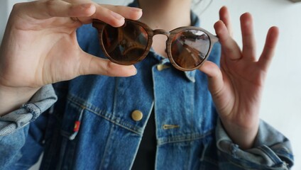 Fashionable woman holding a brown sunglasses