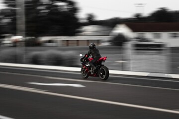 Biker driving fast with a motorcycle leaving the rest of the surrounding in blur