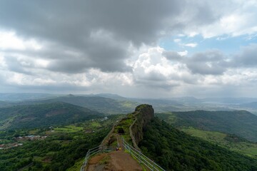 Fototapeta na wymiar Aerial shot of people admiring the view from Lohagad Fort on a clouded day, India