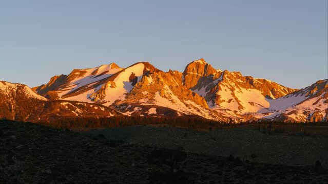 Timelapse of morning sun illuminating alpine peaks in Sierra Nevada mountains, California, USA