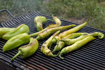 Green peppers on the barbecue grill. Fresh anaheim chili peppers roasting over a charcoal fire....