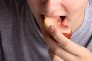 female hand putting a piece of ripe peach in the mouth, healthy food dessert, food lifestyle. Woman...