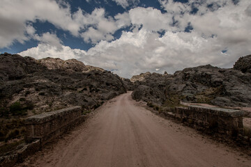 Camino de tierra entre montañas con sectores de puentes con piedra antiguos, Córdoba, Puentes colgantes, Argentina