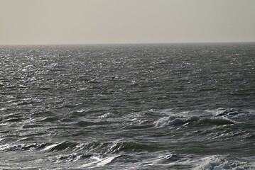 Foamy sea waves approaching the coastline