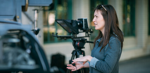 The director of photography is a woman behind a video camera on the set. A professional...