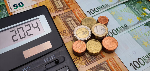 Salary and bonuses in the new year 2024. Calculator, banknotes and euro coins. Budget, inflation,...