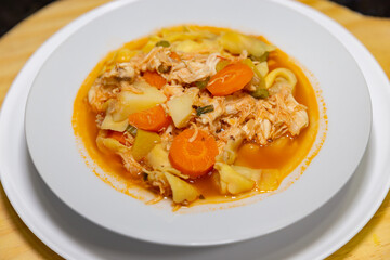 Traditional Italian tortellini (capeletti, agnolini) soup with chicken and vegetables, special soup for cold nights. Closeup