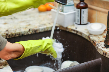 hand-washing dishes, symbolizing equality and shared responsibilities of men and women gender roles responsibilities. Hand washing vs dishwasher technological advances 