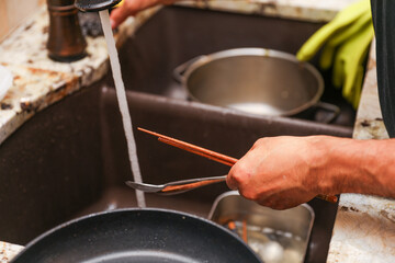 hand-washing dishes, symbolizing equality and shared responsibilities of men and women gender roles responsibilities. Hand washing vs dishwasher technological advances 
