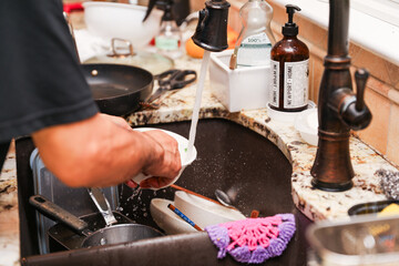hand-washing dishes, symbolizing equality and shared responsibilities of men and women gender roles responsibilities. Hand washing vs dishwasher technological advances 