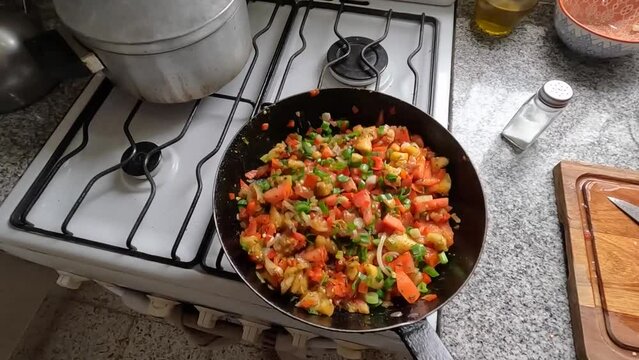 POV view cooking vegetables in a pan at home kitchen