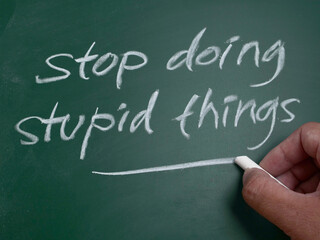 Stop doing stupid things, word text written on chalkboard, motivational inspirational life quotes