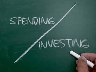 Spending or investing, word text written on chalkboard, business quotes