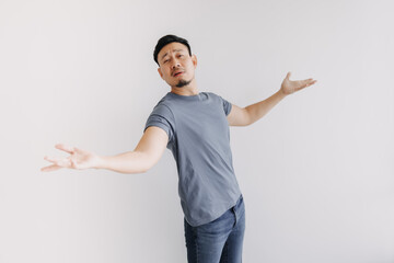 Funny and dramatic asian man is showing and offer hands stand isolated on white.