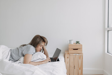 Asian woman sleep on tablet computer on bed in the morning. Early online work.