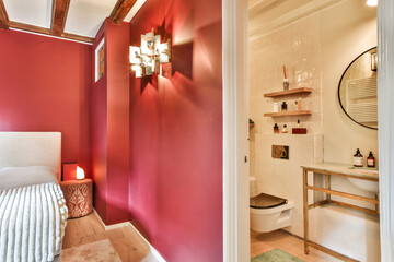 a bathroom with red walls and white trim around the tub, toilet, sink and mirror on the left side