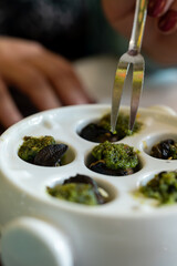Starter dish in traditional restaurants on Burgundy, snails cooked with butter, garlic and herbs, France