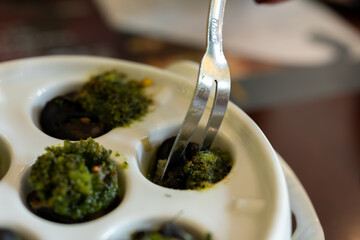 Starter dish in traditional restaurants on Burgundy, snails cooked with butter, garlic and herbs, France