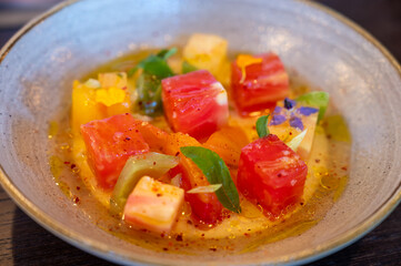 Colorful healthy salad of diced assorted raw French tomatoes served on farm fresh goat’s milk burrata cheese served with vinaigrette dressing