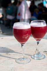 Famous fresh brewed red lambic kriek cherry beer served outside in Belgian beer festival in Durbuy,  special Belgian beer glass in sun lights