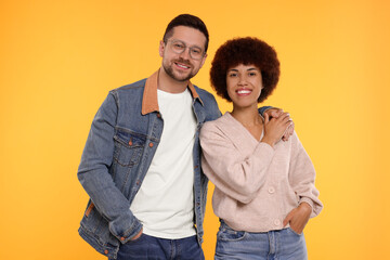 International dating. Portrait of happy couple on orange background