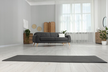 Grey yoga mat on floor in room
