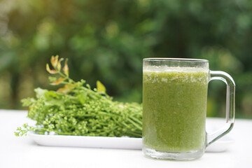 Green smoothie organic herbal vegetables in glass, outdoor background. Concept, healthy beverage...