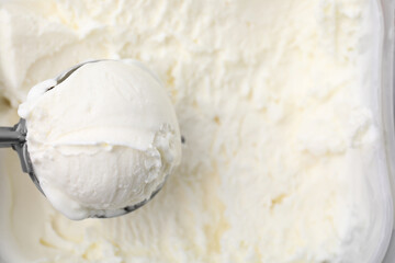 Fototapeta na wymiar Steel scoop with tasty vanilla ice cream, top view. Space for text