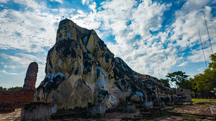 .scenery sunrise The temple is ruin but the Buddha is completely perfect..White clouds in the blue sky above the reclining Buddha statue at .the Religious History Park.