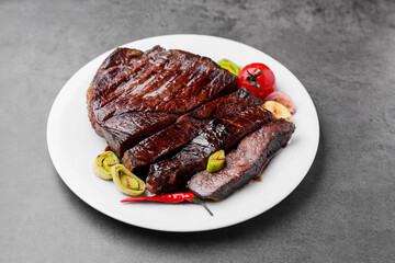 Delicious grilled beef meat on grey table, closeup
