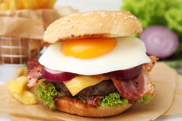 Delicious burger with fried egg on table, closeup