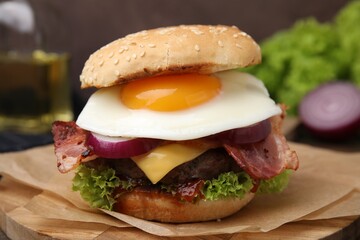 Delicious burger with fried egg on table, closeup