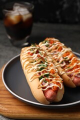 Delicious hot dogs with bacon, carrot and parsley on table, closeup