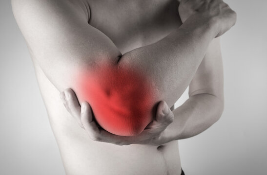 A man has pain in his elbow and tendon muscles and he relieves the pain with a massage. Health and healing concept
