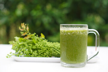 Green smoothie organic herbal vegetables in glass, outdoor background. Concept, healthy beverage...
