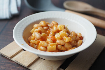Tasty baked beans in a bowl on table 