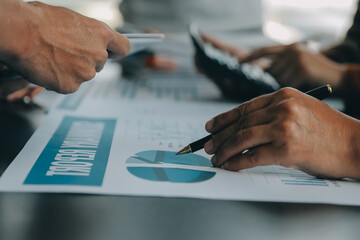 Financial analysts analyze business financial reports on a digital tablet planning investment project during a discussion at a meeting of corporate showing the results of their successful teamwork.