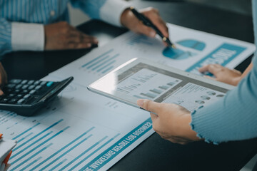 Financial analysts analyze business financial reports on a digital tablet planning investment project during a discussion at a meeting of corporate showing the results of their successful teamwork.