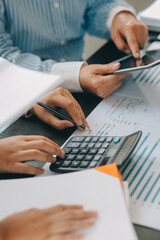 Financial analysts analyze business financial reports on a digital tablet planning investment project during a discussion at a meeting of corporate showing the results of their successful teamwork.