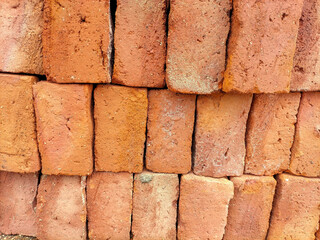 Selective focus. Red bricks from clay. Many clay is molded into bricks, after that it is laid out and dried in the yard in the sun before being burned to make it hard and dry. Pile of making batu bata