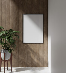 wooden frame mockup poster hanging on the wooden panel wall with plant decoration.