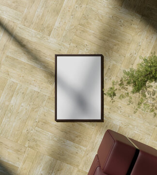 wooden frame mockup poster laying up on the wooden floor with tree and sofa from top view