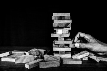 Hand pull wooden block tower stack in pyramid stair step with caution to prevent collapse or crash...