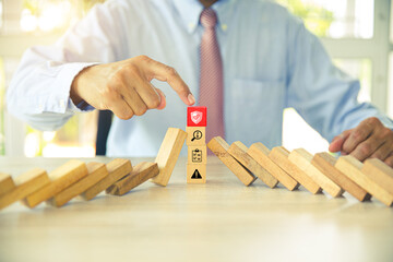 Hand to stop wooden block prevent not falling domino concepts of financial risk management and strategic planning and business challenge plan or safety insurance.