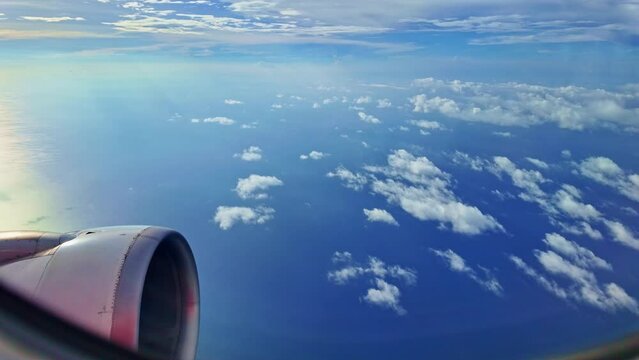 .from the airplane window Propeller and wings next to the window..an airplane flying past fluffy white clouds..The slope of the horizon shifts with the plane.The atmosphere in the sky is beautiful.